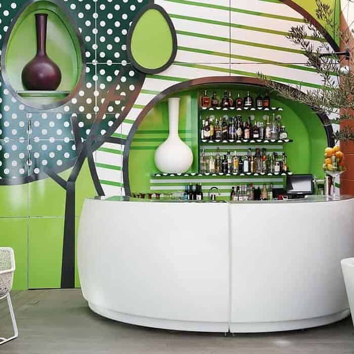 Bunte Bar mit grüner Farbgestaltung, Keramik Grill 24, stilvolle Einrichtung.