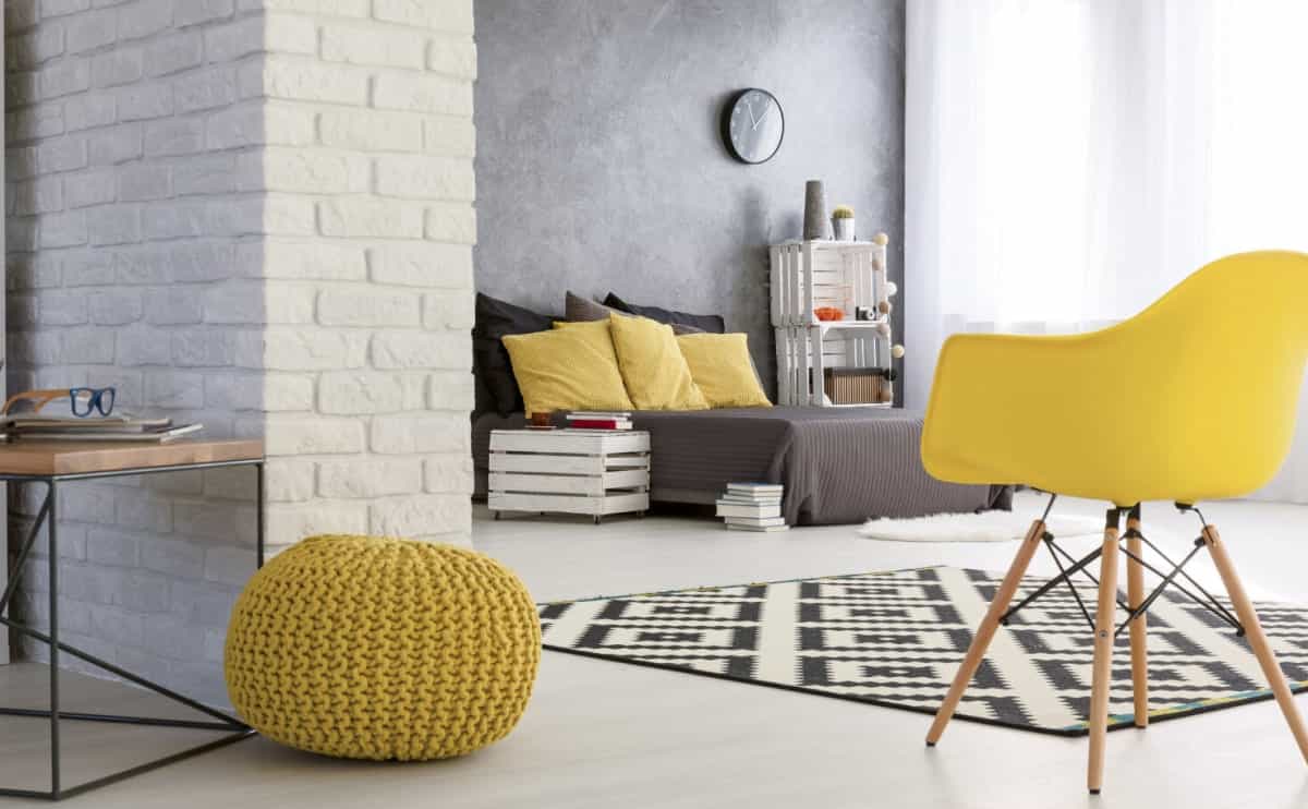 Moderne Wohnraumgestaltung mit Keramikgrill und stilvollen Sitzmöbeln in hellem Farbkonzept.